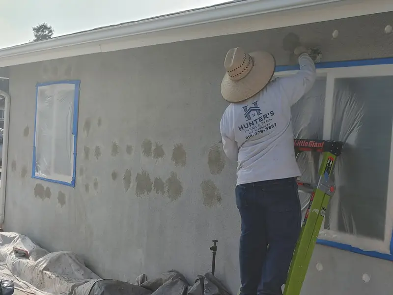 Crew member patching a wall after drill and fill