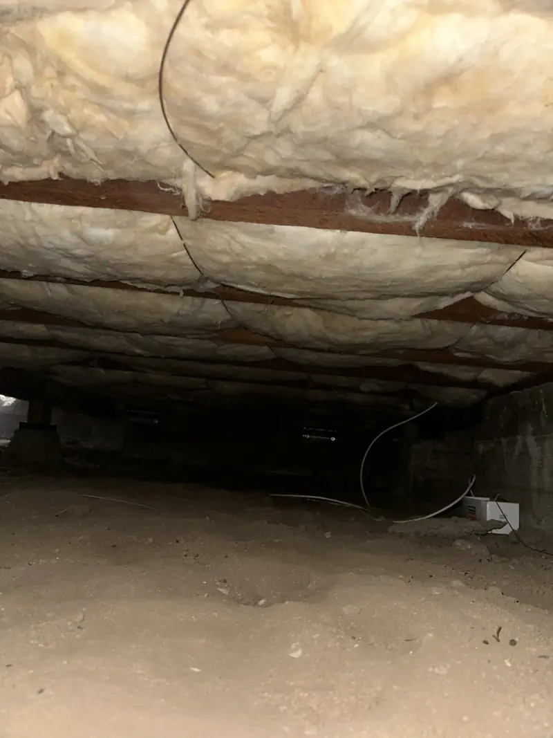Insulation installed under a raised floor in a crawl space