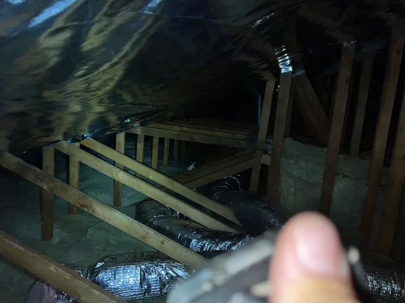 Inspecting an attic with a flashlight