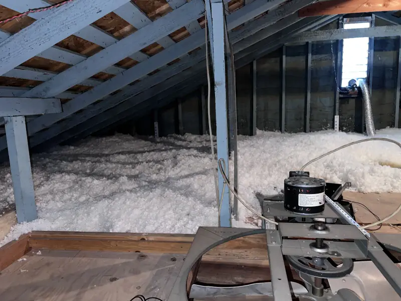 Insulation blowing machine set up in an attic